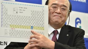 Kosuke Morita, le leader de l'équipe de l'institut Riken, arbore un sourire alors qu'il montre le tableau périodique complété avec le nouvel élément 113, lors d'une conférence de presse à Wako, au Japon, le 31 décembre 2015.