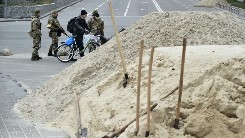 Un habitant de Kiev en train de traverser à vélo près d'un barrage anti-tank ce samedi.