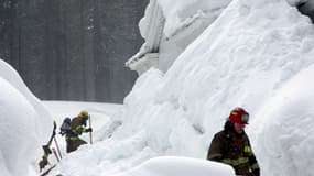 Des pompiers interviennent dans un village enneigé de Californie, mars 2023 