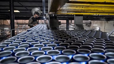 Un ouvrier contrôlant des canettes de bière sur une chaîne de production de la brasserie Murree à Rawalpindi (Paskistan), le 17 décembre 2025