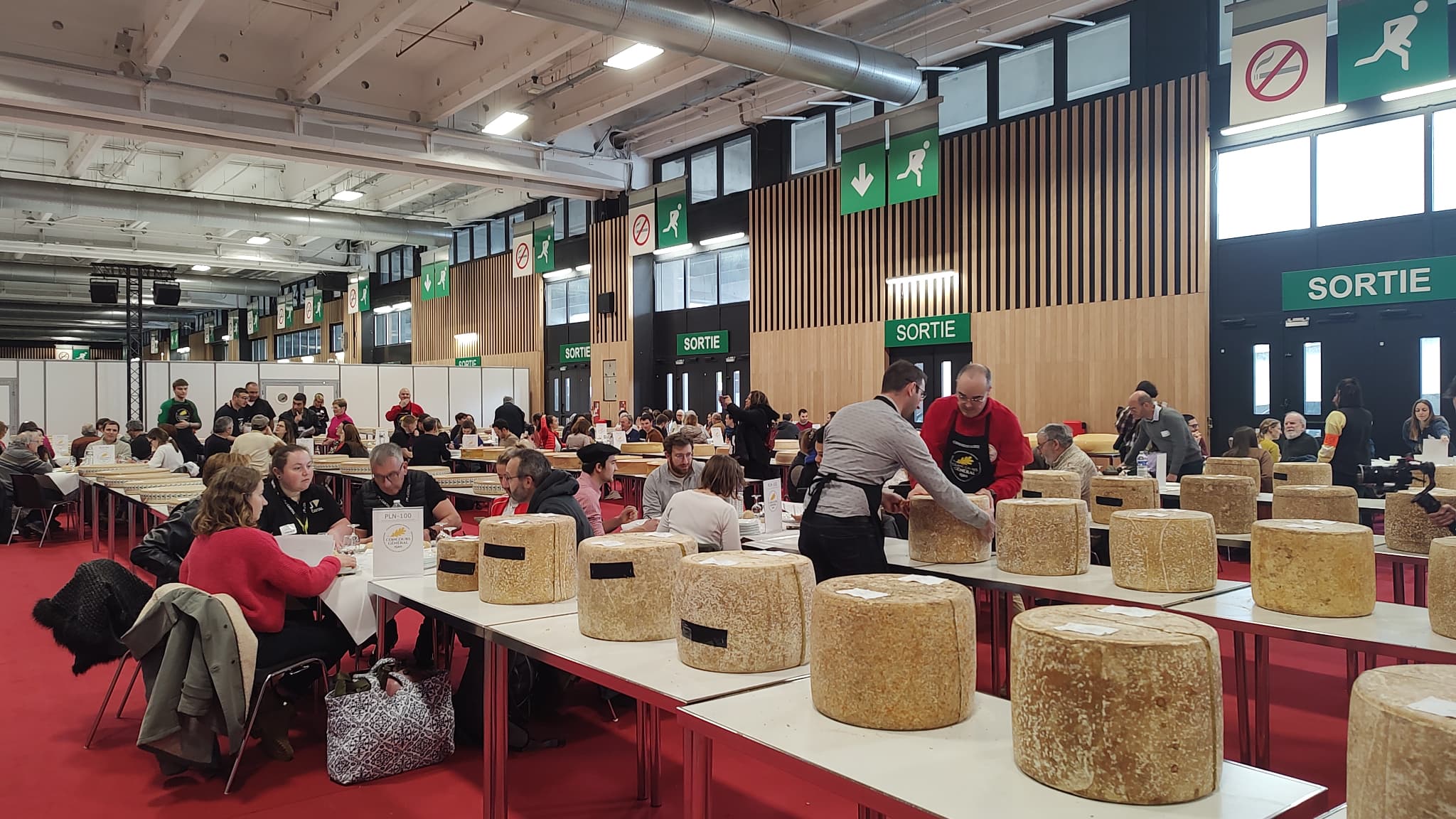 Des jurés s'installant autour des tables lors des finales du Concours général agricole dans la catégorie des produits laitiers, le 25 février 2025 à Paris.
