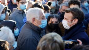 Le président français Emmanuel Macron (droite) avec des habitants de Saint-Leonard de Noblat, dans le centre de la France, le 25 janvier 2022