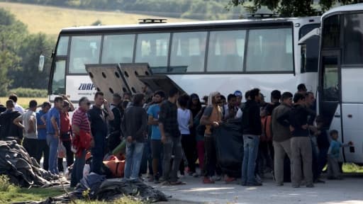 Des migrants montent à bord d'un bus le 23 mars 2016 à Idomeni