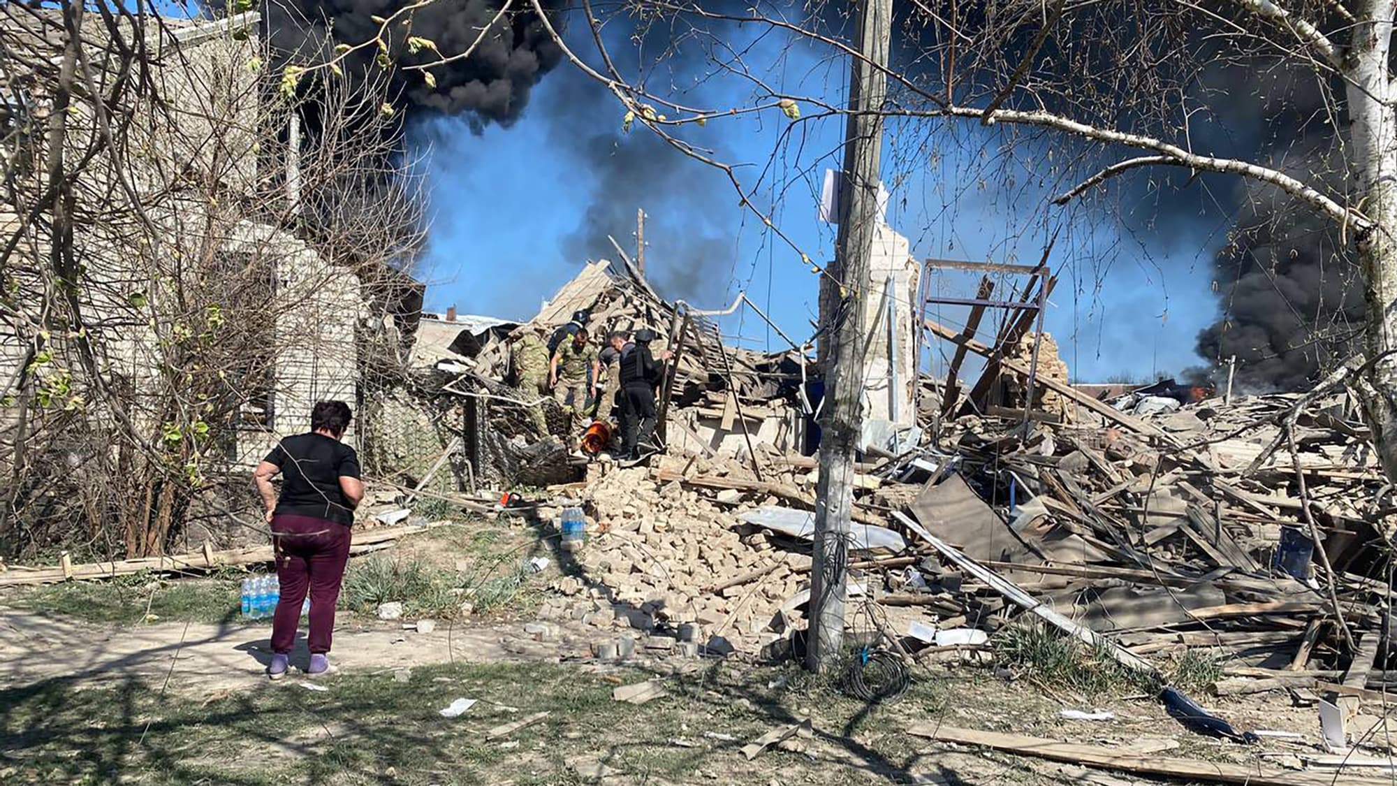 Des secouristes travaillent sur le site d'une attaque au missile qui a tué un enfant et deux femmes à Lyptsi, dans la région de Kharkiv, le 10 avril 2024.