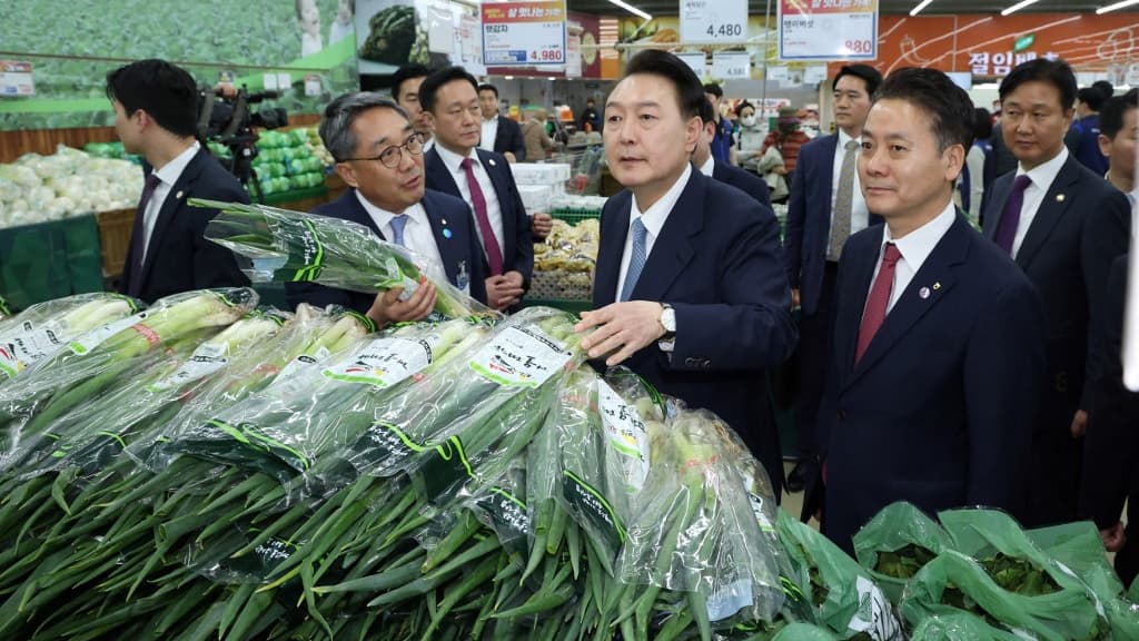 Le président sud-coréen Yoon Suk Yeol devant plusieurs bottes d'oignon vert, le 18 mars 2024 