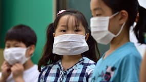 Des enfants portent des masques de protection lors d'un cours de prévention contre le coronavirus MERS, le 2 juin, à Séoul, en Corée du Sud. 