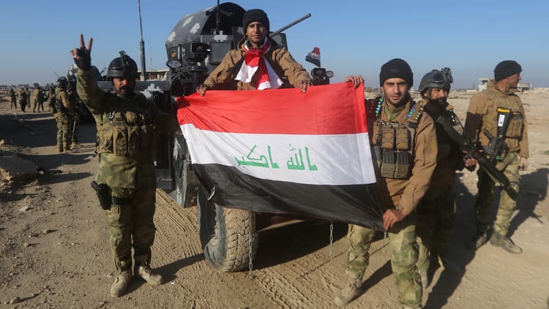 Des membres des forces irakiennes posent avec le drapeau national à Ramadi, après leur victoire sur Daesh, le 29 décembre.