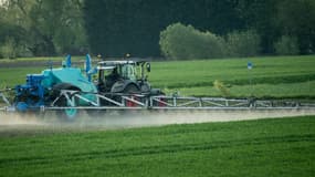 Un tracteur répand des pesticides sur un champ (image d'illustration)