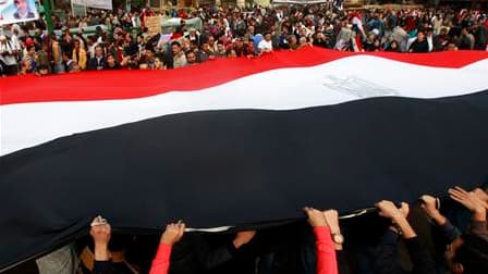 Partisans de l'opposition déployant un drapeau égyptien sur la place Tahrir, au Caire. Alors que la mobilisation ne faiblit pas sur l'immense place du centre de la capitale égyptienne, le gouvernement égyptien a dénoncé ce qu'il a qualifié de tentatives a