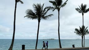 Des femmes marchent dans une rue déserte de Nouméa en Nouvelle-Calédonie, le 7 septembre 2021 alors que l'île est de nouveau confinée en raison de la flambée de la pandémie de Covid-19