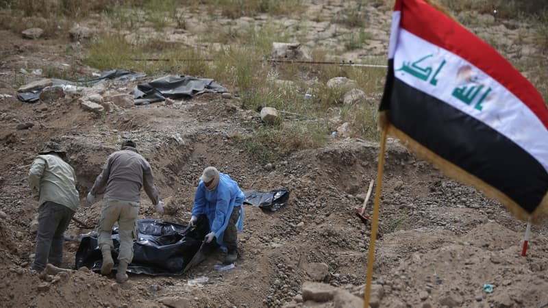 Des membres des forces de sécurité irakiennes inspectent un charnier contenant les restes de militaires tués par Daesh lors du massacre de Tikrit en 2014, auquel Ahmed H. est soupçonné d'avoir participé.