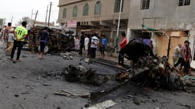 Sur les lieux d'un attentat dans le quartier de Kamaliya, à Bagdad. Une soixantaine de personnes ont été tuées dans une série d'attentats à la voiture piégée visant la communauté chiite lundi en Irak. /Photo prise le 20 mai 2013/REUTERS/Mohammed Ameen