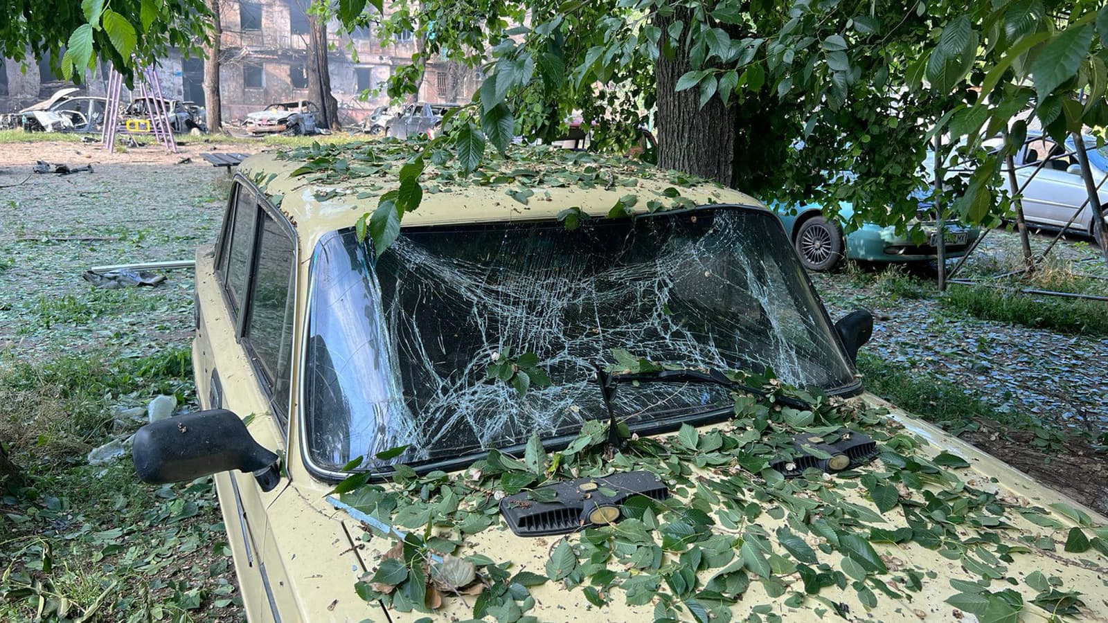 Cette photo diffusée par la police nationale ukrainienne le 13 juin 2023 montre des voitures endommagées et détruites à côté d'un immeuble résidentiel de cinq étages détruit lors d'une attaque russe nocturne, dans la ville de Kryvyi Rih.