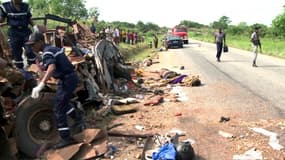 Des sauveteurs burkinabés inspectent la carcasse d'un bus après un accident de la route près de Bouaké, le 27 mars 2012