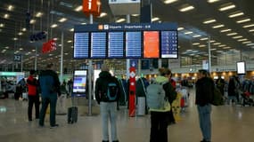 Des voyageurs consultent des panneaux d'information sur les vols à l'aéroport d'Orly, près de Paris, le 25 avril 2024
