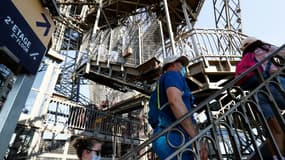 Des visiteurs montent les escaliers de la Tour Eiffel, le jour de sa réouverture, le 25 juin 2020 à Paris