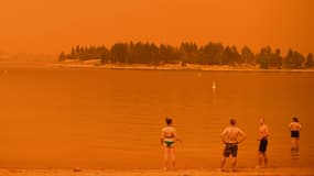 Des personnes en Australie sous un ciel rouge causé par les incendies ce samedi 4 janvier