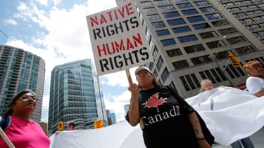Une femme tient une pancarte "Droits des Amérindiens = Droits humains" lors d'une manifestation à Toronto, le 24 juin 2010.