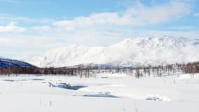 La rivière Tarra au milieu d'un paysage enneigé, dans le nord de la Suède.