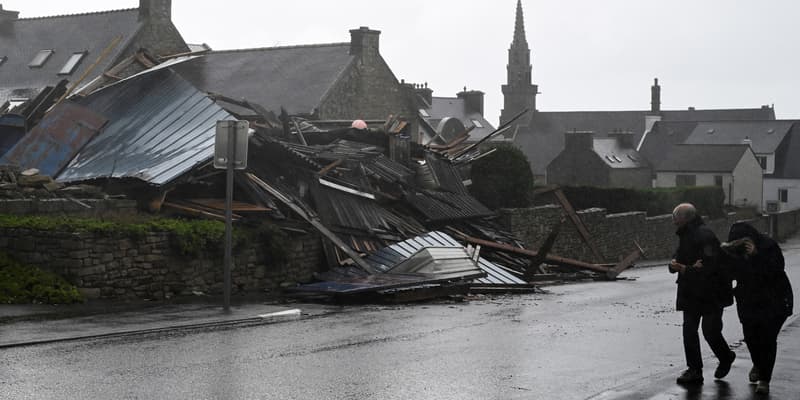 Des piétons passent devant un entrepôt détruit à Porspoder (Finistère) par la tempête Ciarán, le 2 novembre 2023.