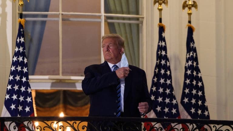 Le président américain Donald Trump retire son masque sur le balcon de la Maison Blanche après son retour de l'hôpital, le 5 octobre 2020