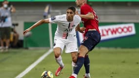 L'arrière droit du PSG Achraf Hakimi (g) déborde l'attaquant lillois Burak Yilmaz lors du Trophée des champions, le 1er août 2021 à Tel-Aviv 