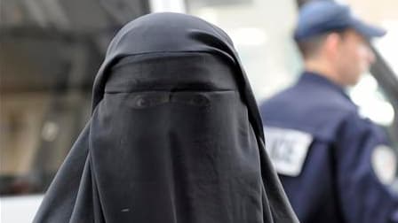 Une femme portant le voile intégral islamique sort d'un poste de police, à Paris. Quatre femmes ont été verbalisées depuis l'entrée en vigueur, il y a une semaine, de la loi qui interdit le port du voile intégral en public. /Photo prise le 11 avril 2011/R