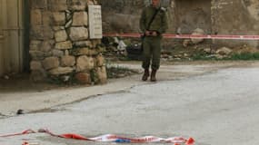 Un militaire israélien surveille le lieu où une autre jeune Palestinienne a tenté de poignarder un soldat israélien avant d'être abattue, dans la ville d'Hebron, le 13 février 2016