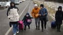 Des réfugiés ukrainiens franchissent la frontière pour entrer en Pologne entre les villes de Medyka et Shehyni le 28 février