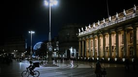 Un livreur de nourriture circule à vélo devant le Grand Théâtre de Bordeaux, dans le sud-ouest de la France, le 29 octobre 2020