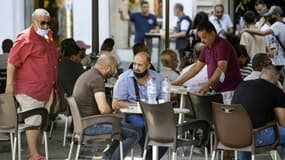 Des personnes sont assises à une terrasse de café le long de l'avenue Habib Bourguiba à Tunis,  le 28 juillet 2021