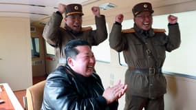Photo diffusée le 25 mars 2022 par l'agence nord-coréenne Kcna du dirigeant nord-coréen Kim Jong Un (c) applaudissant pendant un tir un missile balistique intercontinental Hwasong-17 dans un lieu non précisé en Corée du Nord, le 24 mars 2022