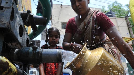 Une femme et sa fille à une source d'eau potable, en Inde, en avril 2012.