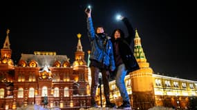 De jeunes gens brandissent les lampes torches de leur téléphone portable en signe de soutien à Alexei Navalny ce dimanche à Moscou.