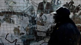 Une femme devant un graffiti représentant les événements du 16 juin 1976 à Soweto