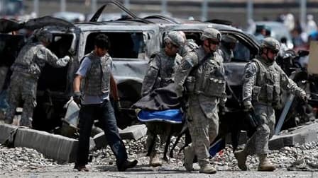 Soldats américains sur les lieux d'un attentat suicide au véhicule piégé, mardi à Kaboul. Cette attaque contre un convoi de l'Otan a coûté la vie à 12 civils et à cinq soldats étrangers au moins. /Photo prise le 18 mai 2010/REUTERS/Ahmad Masood