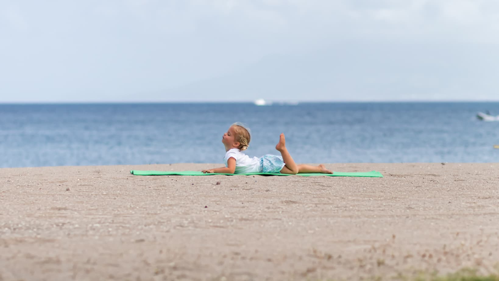 Un enfant en train de s'étirer sur la plage du Four Seasons Resort Punta Mita.