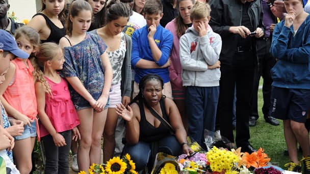 Des anonymes rendent hommage à "Maniba" devant sa maison de Johannesburg, au lendemain de sa mort.