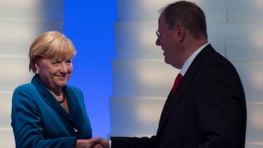 Angela Merkel serre la main à son rival Peer Steinbrück après sa victoire. Les deux partis, CDU et SPD, sont d'accord pour gouverner ensemble.