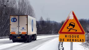 Un camion passe devant un panneau de signalisation annonçant du verglas sur une route enneigée le 18 décembre 2009 à Saint-Saens. Photo d'illustration
