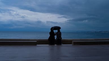 Deux passants sous un parapluie sur la promenade des Anglais à Nice, le 1er mai 2024