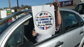 Un homme tient une affiche "Le convoi de la liberté" depuis sa voiture à Bayonne, le 9 février 2022