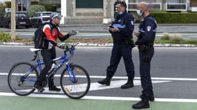 Un cycliste contrôlé par deux policiers en période de confinement, à La Baule, le 13 avril 2020