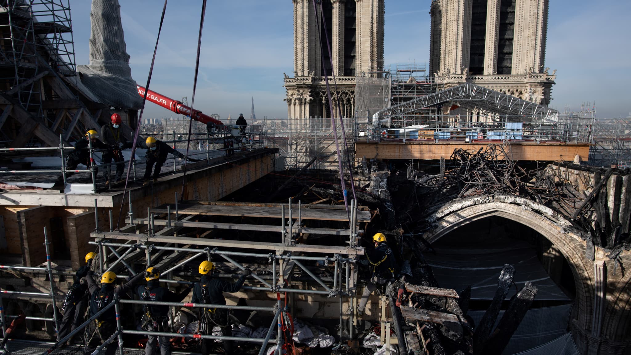 Des ouvriers s'attelant au démantèlement de l'échafaudage sinistré de la cathédrale Notre-Dame de Paris le 24 novembre 2020, lors des travaux de reconstruction du monument.