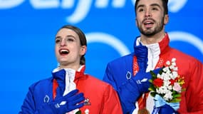 Gabriella Papadakis et Guillaume Cizeron chantent la Marseillaise sur le podium lors de la cérémonie protocolaire, après avoir remporté le titre olympique de danse sur glace, le 14 février 2022 aux Jeux de Pékin