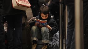 Un jeune lecteur de Picsou Magazine dans une gare, en décembre 2010