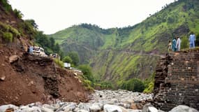 Des badauds se rassemblent près d'un pont détruit après des crues soudaines dans la banlieue de Muzaffarabad, la capitale du Cachemire sous administration pakistanaise, le 15 août 2025. 