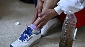Une femme enduit sa jambe d'alcool dans lequel de la marijuana a macéré pour soulager ses douleurs musculaires à Mexico le 30 novembre 2015