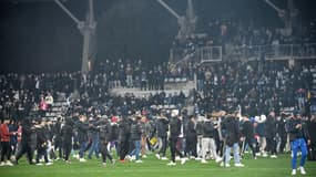 Des supporters entrés sur le terrain du stade Charléty de Paris à la mi-temps du 32e de finale de Coupe de France entre le Paris FC et Lyon le 17 décembre 2021, arrêté définitivement en raison d'incidents en tribunes