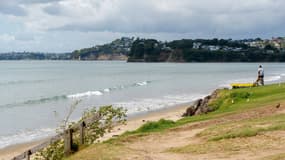 Un homme regarde la mer à Orewa, au nord d'Auckland, le 5 mars 2021